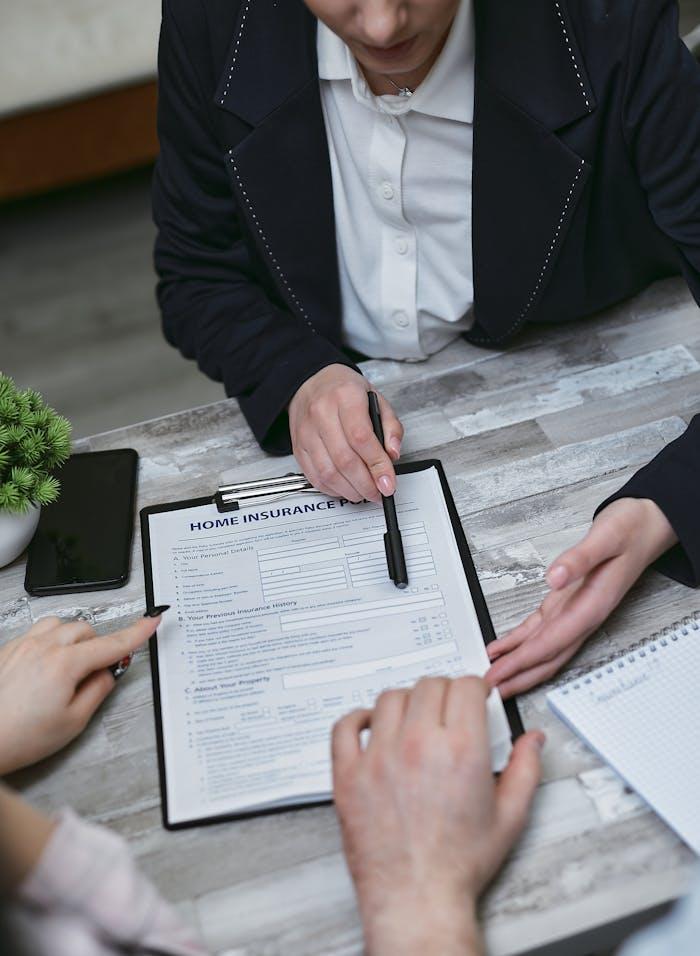 Life & Health 3 An agent and clients discussing paperwork for home insurance at a meeting table.